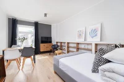 a bedroom with a bed and a table and chairs at One bedroom apartment Kalwaryjska 34 street in Kraków