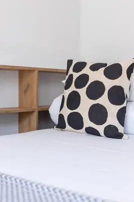 a bed with black and white polka dot pillows at One bedroom apartment Kalwaryjska 34 street in Kraków