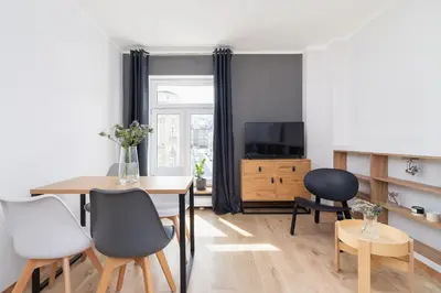 a living room with a table and chairs and a television at One bedroom apartment Kalwaryjska 34 street in Kraków