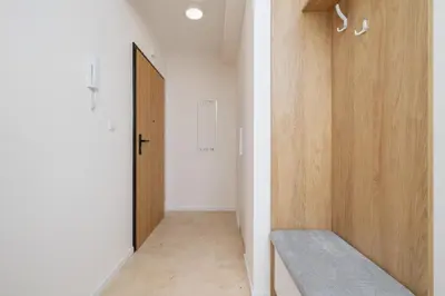 a hallway with a door and a bench in a room at Kalwaryjska 34 street Studio with balcony in Kraków
