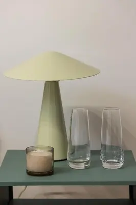 two glasses and a lamp on a green table at Kalwaryjska 34 street Studio with balcony in Kraków