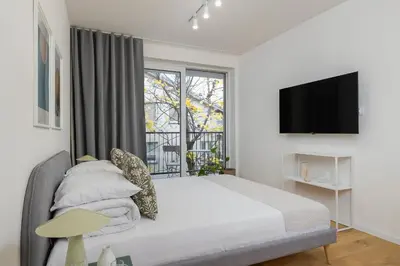 a bedroom with a bed with a tv and a window at Kalwaryjska 34 street Studio with balcony in Kraków