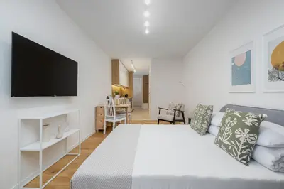a bedroom with a bed and a flat screen tv at Kalwaryjska 34 street Studio with balcony in Kraków