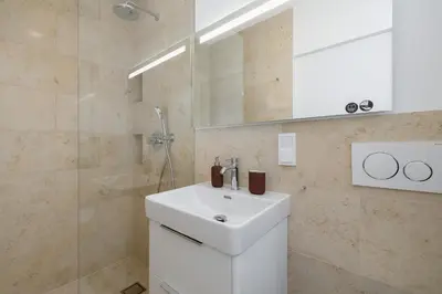 a bathroom with a white sink and a shower at Kalwaryjska 34 street Studio with balcony in Kraków