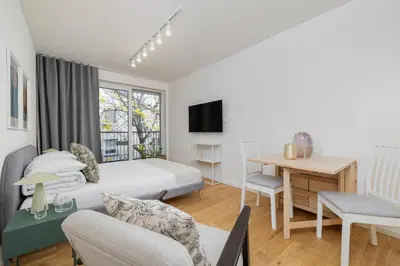 a hotel room with a bed and a desk and a table at Kalwaryjska 34 street Studio with balcony in Kraków