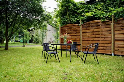 a table and chairs in a yard with a fence at Magic Apartments - Garden in Zator