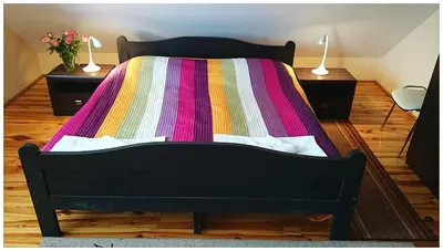 a bed with a colorful blanket on it in a room at Hotel GoGreen *** in Kraków