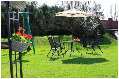 a table and chairs with an umbrella in the grass at Hotel GoGreen *** in Kraków
