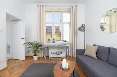 a living room with a gray couch and a table at Apartment with balcony - Paulinska 8 street in Kraków