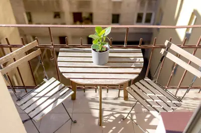 a table with two chairs and a potted plant on a balcony at Apartment with balcony - Paulinska 8 street in Kraków