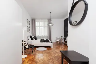 a living room with a white couch and a mirror at Kazimierz District - Paulińska 18 Street in Kraków