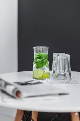 a glass vase with a lime on a table at Kazimierz District - Paulińska 18 Street in Kraków