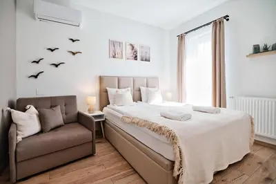 a bedroom with a bed and a chair and bats on the wall at Jaśminowa Ostoja Zator by Housine in Zator