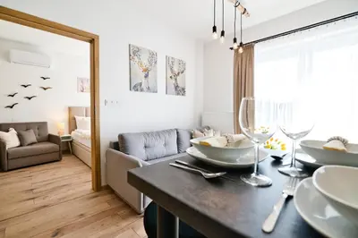 a living room with a dining table and a living room at Jaśminowa Ostoja Zator by Housine in Zator