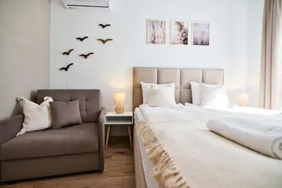 a bedroom with a bed and a couch and birds at Jaśminowa Ostoja Zator by Housine in Zator