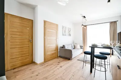 a kitchen and living room with a table and chairs at Jaśminowa Ostoja Zator by Housine in Zator