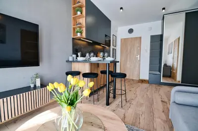 a living room with a vase of flowers on a table at Jaśminowa Ostoja Zator by Housine in Zator