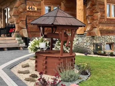 a wooden gazebo in front of a building at Domek na Wierchu Bukowiny in Załuczne