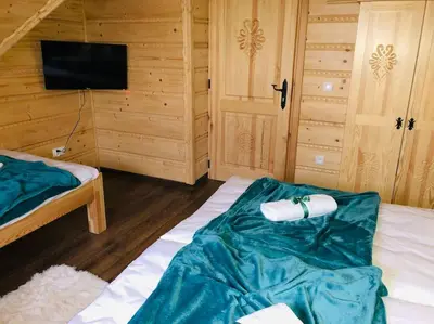 a bedroom with a bed with a roll of toilet paper on it at Domek na Wierchu Bukowiny in Załuczne
