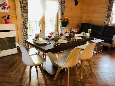 a dining room table and chairs in a living room at Domek na Wierchu Bukowiny in Załuczne