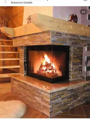 a brick fireplace with a fire in it at Domek na Wierchu Bukowiny in Załuczne