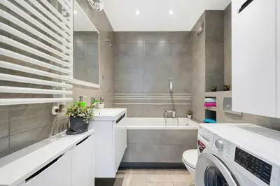 a bathroom with a sink and a washing machine at Apartament Chrobrego Wieliczka 2 in Wieliczka