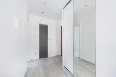 an empty room with white walls and mirrors at Apartament Chrobrego Wieliczka 2 in Wieliczka