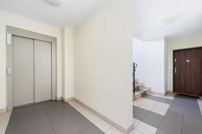 a hallway with a door and a tiled floor at Apartament Chrobrego Wieliczka 2 in Wieliczka