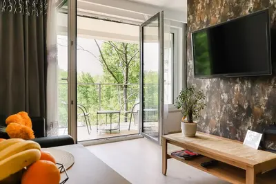 a living room with a flat screen tv on a wall at Strumienna Apartament in Kraków