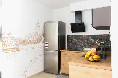 a kitchen with a refrigerator and a bowl of fruit at Strumienna Apartament in Kraków