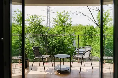 a patio with two chairs and a table on a balcony at Strumienna Apartament in Kraków