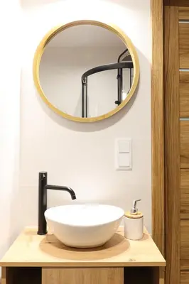 a bathroom with a white sink and a mirror at Strumienna Apartament in Kraków