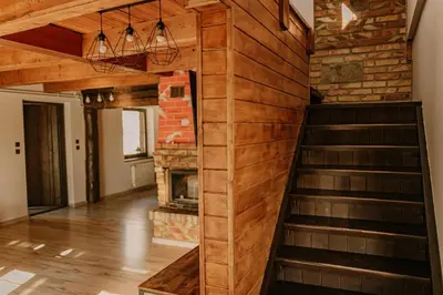 a living room with a staircase and a fireplace at Domek Zacisze Zator Graboszyce in Graboszyce