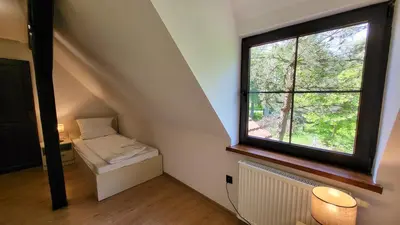 an attic room with a window and a radiator at Domek Zacisze Zator Graboszyce in Graboszyce