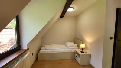 a small bed in a small room with a window at Domek Zacisze Zator Graboszyce in Graboszyce