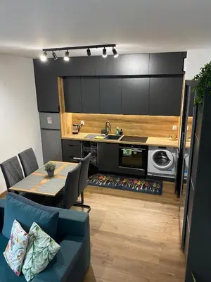 a kitchen and living room with a table and a couch at EM Room in Kraków