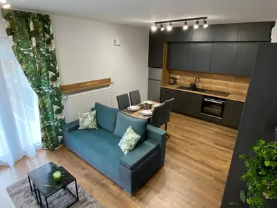 a living room with a blue couch and a table at EM Room in Kraków