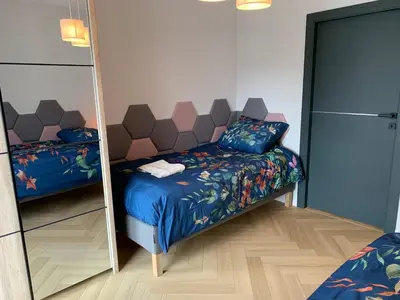 a bedroom with a mirror next to a bed and a bed sqor at Apartment Krakow City-Arena in Kraków