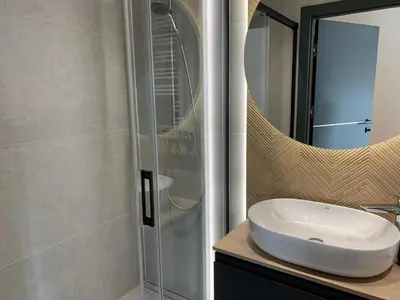 a bathroom with a sink and a glass shower at Apartment Krakow City-Arena in Kraków
