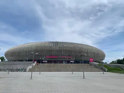 a large circular building with stairs in front of it at Apartment Krakow City-Arena in Kraków