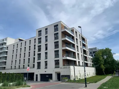 a white building on a street with a stop sign at Apartment Krakow City-Arena in Kraków