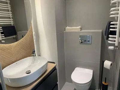 a bathroom with a white sink and a toilet at Apartment Krakow City-Arena in Kraków