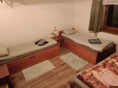 two beds in a room with wooden floors at Drewniany domek na wynajem Beskid Wyspowy in Limanowa