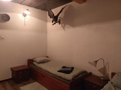 a bird flying over a bed in a bedroom at Drewniany domek na wynajem Beskid Wyspowy in Limanowa
