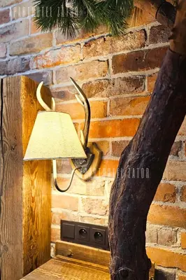 a lamp on a brick wall next to a tree at Aparthotel ZATOR Natural 56 jacuzzi in Zator