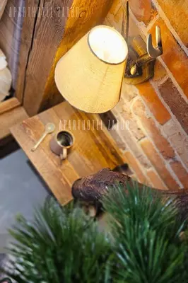 a lamp on a wooden table with a christmas tree at Aparthotel ZATOR Natural 56 jacuzzi in Zator
