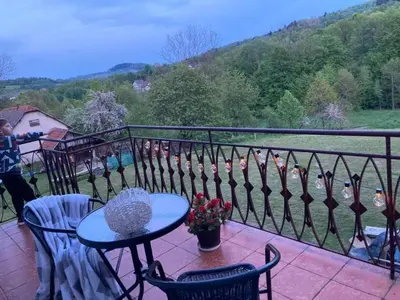 a balcony with a table and chairs and birds on a fence at Zaciszny zakątek pod Różą in Skawinki
