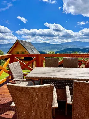 a table and chairs on a deck with a view at Sielska Chata Beskidy in Zawoja