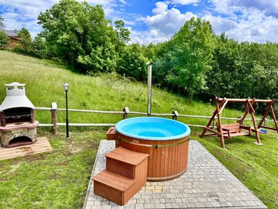 a hot tub and a swing in a yard at Sielska Chata Beskidy in Zawoja