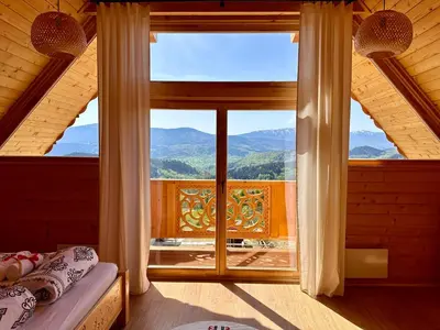 a bedroom with a large window with a view of mountains at Sielska Chata Beskidy in Zawoja
